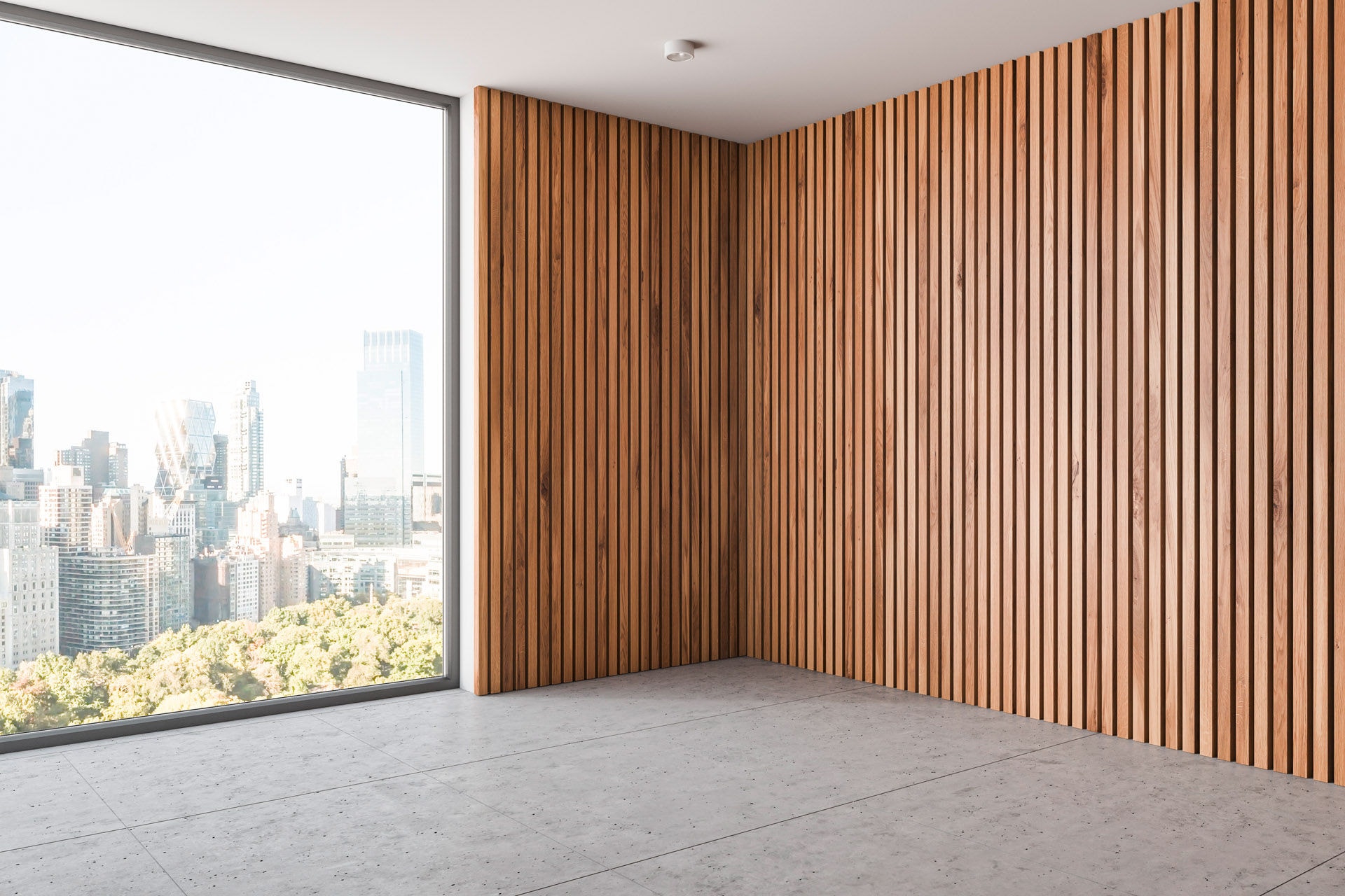 Corner of empty room with light wooden walls, concrete floor, stylish ceiling lamps and large window with cityscape. 3d rendering